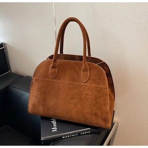 Détail du sac cabas en daim caramel avec poignées renforcées et coutures précises