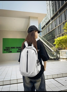 Close-up of a white minimalist backpack with waterproof fabric and vertical black zipper