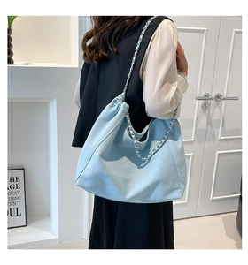 Detail der hellblauen Denim-Tasche mit Kordelzug und silberner Ketten-Schulterriemen