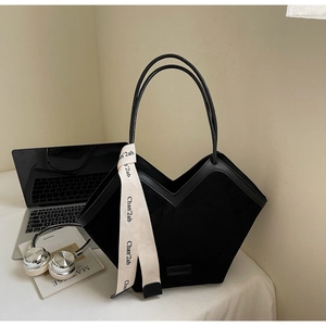 Detail of black frosted tote bag featuring a V-shaped top edge and chic beige ribbon decor