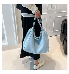 Detailansicht der hellblauen Denim-Einkaufstasche mit Silberkette und Texturgewebe