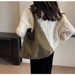Deep olive green suede hobo bag shown from the back on a model wearing a white sweater