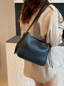 Minimalist black hobo shoulder bag for women with wide strap and tassel detail