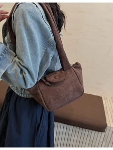 Brown suede-textured bucket bag featuring pleated design and comfortable wide shoulder strap