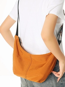 Lightweight orange nylon crescent crossbody bag with adjustable strap and textured finish