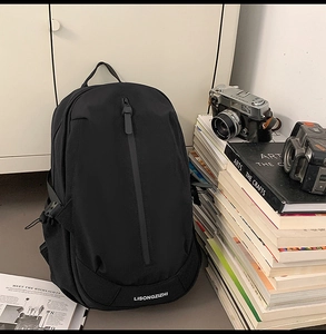 Detail of minimalist black backpack with vertical zipper and brand logo in a cozy setting