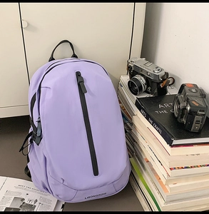 Detail of light purple nylon backpack with vertical zipper against a lifestyle background