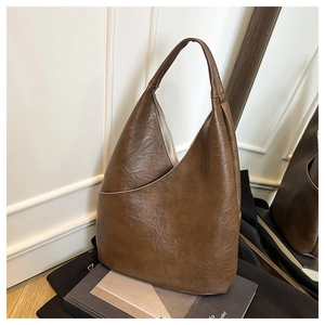 Vista dettagliata della trama in pelle marrone scuro e cuciture di una borsa hobo