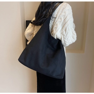 Minimalist black matte shoulder bag shown on model highlighting large capacity and sleek shape