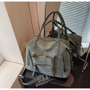 Detail view of military green tote bag showing multi-pocket design and matte texture