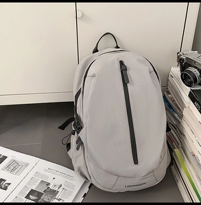 Detailed view of the gray waterproof travel backpack with black vertical zipper accents
