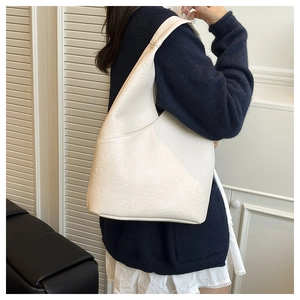 Dettaglio della grande borsa hobo crema che mostra la pelle morbida e il design rilassato