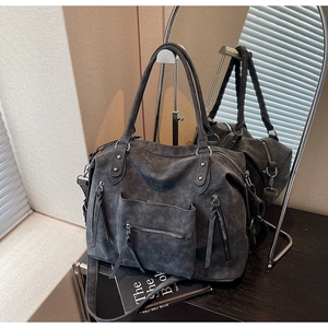 Detail view of dark grey vintage tote bag with fringe zippers and multi-pocket design