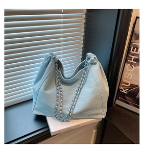 Detailaufnahme der hellblauen Denim Hobo-Bag mit silbernen Ketten und Raffungen