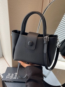 Fashionable black pebble grain leather bucket bag with top handles and crossbody strap