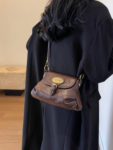 Vintage dark brown oil wax leather crossbody bag with gold metal plaque on black coat