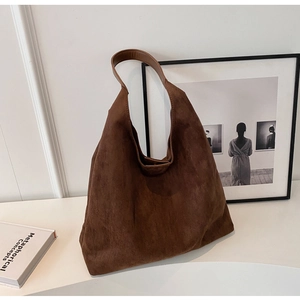 Detailed view of deep brown suede tote bag with magnetic closure and smooth leather strap
