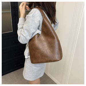 Vista dettagliata della borsa hobo marrone con texture in pelle retrò e design morbido
