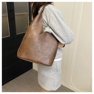 Dettaglio della borsa tote retrò marrone scuro in ecopelle martellata con taglio a triangolo