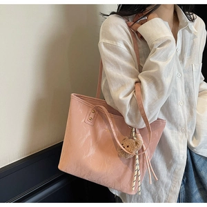 Close-up of pink tote bag with marble texture and brown bear keychain accessory