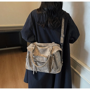 Detail view of large grey vintage PU leather tote bag worn by model in a minimalist setting