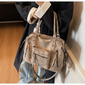 Dettaglio della borsa tote vintage marrone con tasche con zip e finitura in pelle