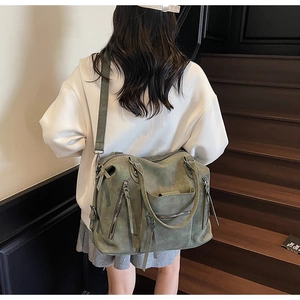 Close-up of olive green oversized tote bag with vintage matte leather and zipper details