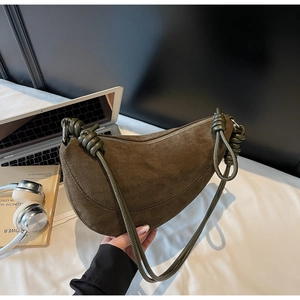 Detail view of olive green suede crescent bag with unique knotted rope strap design