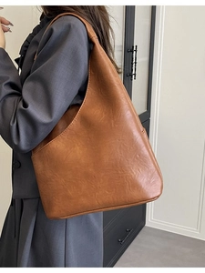 Borsa tote vintage in pelle marrone grande capacità indossata da modella a spalla
