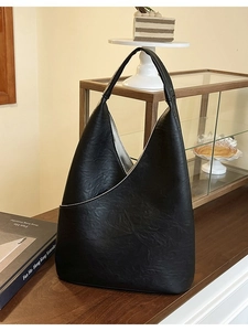 Grande borsa tote vintage nera con esclusivo design a pieghe triangolari su tavolo