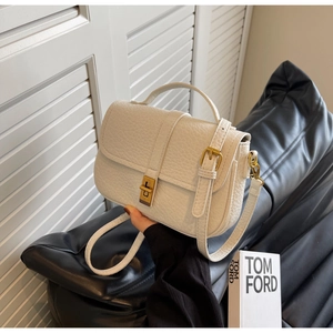 Detail of white lychee leather handbag featuring vintage metal buckle and adjustable strap