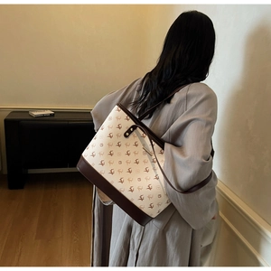 Schicke beige Tragetasche mit Hirschmuster und braunen Lederriemen an einem Model