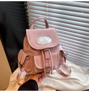 Gros plan du mini sac à dos en cuir rose avec plusieurs poches et boucles métalliques