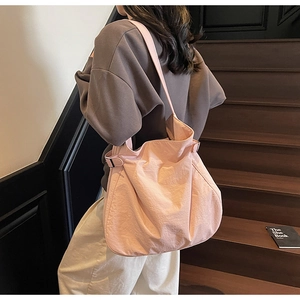 Close-up of pink oversized tote bag featuring adjustable metal buckle and褶皱 texture