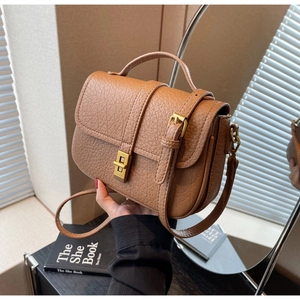 Detail of caramel brown bag with lychee texture leather and vintage golden metal lock