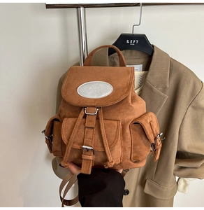 Gros plan du sac à dos en daim marron avec poches vintage et fermeture à cordon