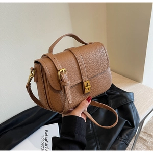 Close-up of brown pebble grain leather handbag with vintage gold swivel lock detail