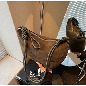 Detail of suede crescent bag with knotted shoulder strap and olive green finish