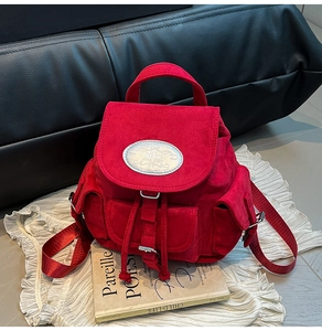 Détail du sac à dos en daim rouge avec plaque nika et fermeture à cordon de style rétro