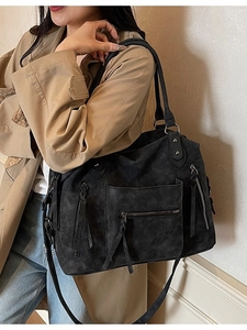 Large black suede tote bag with front zippers and crossbody strap shown on a model