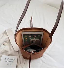 Vue macro de l'intérieur spacieux du sac fourre-tout en daim marron avec tablette et mobile