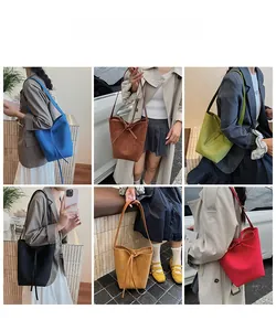 Detail showcasing six colors of suede bucket bags with drawstring bow accents in daily use