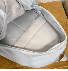 Interior view of light blue backpack featuring a padded laptop compartment and velcro strap