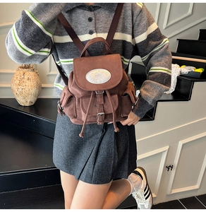 Détail d'un sac à dos en daim marron avec rabat et cordon de serrage pratique