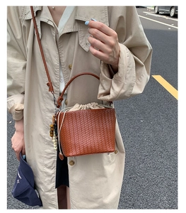 Detail einer braunen Flecht-Beuteltasche mit Kreuzwebstruktur und praktischem Kordelzug
