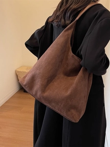 Brown suede tote bag with large capacity shown on model in a minimalist interior