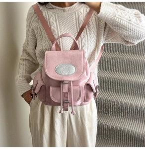 Détail du sac à dos en daim rose avec fermeture à cordon et boucle métallique