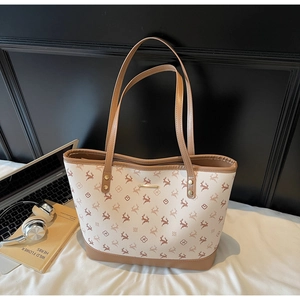 Detailansicht der bedruckten Shopper-Tasche mit Metalldetails neben Laptop und Kopfhörer