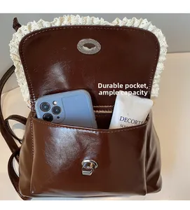 Detail view of large front pocket and spacious interior of brown leather backpack