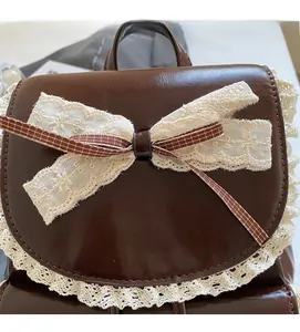 Detailed view of vintage brown leather backpack with lace trim and bow knot decoration